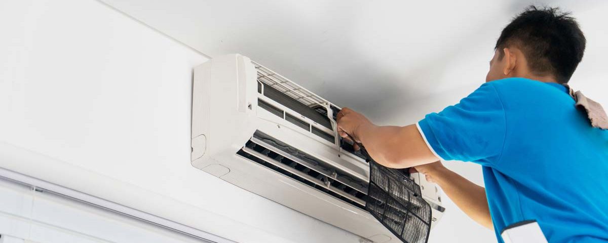 Klimaanlage Wartung: Ein Mann wartet eine Klimaanlage